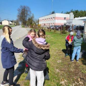 Uczniowie klasy 2 zbierają śmieci na trasie drogi do miejscowości Łubno.