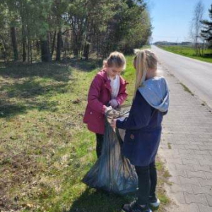 Uczniowie klasy 2 zbierają śmieci na trasie drogi do miejscowości Łubno.