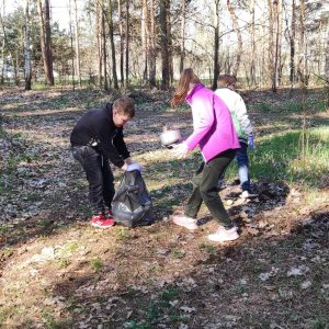 Uczniowie klasy 4 zbierają śmieci wzdłuż drogi do lasu