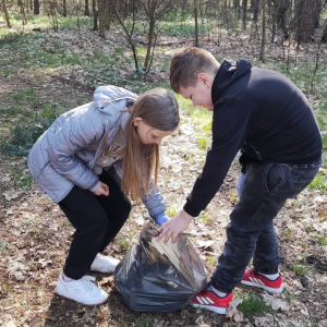 Uczniowie klasy 4 zbierają śmieci wzdłuż drogi do lasu