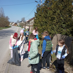 Uczniowie kl. III dzielą się obowiązkiem dźwigania worka z zebranymi śmieciami